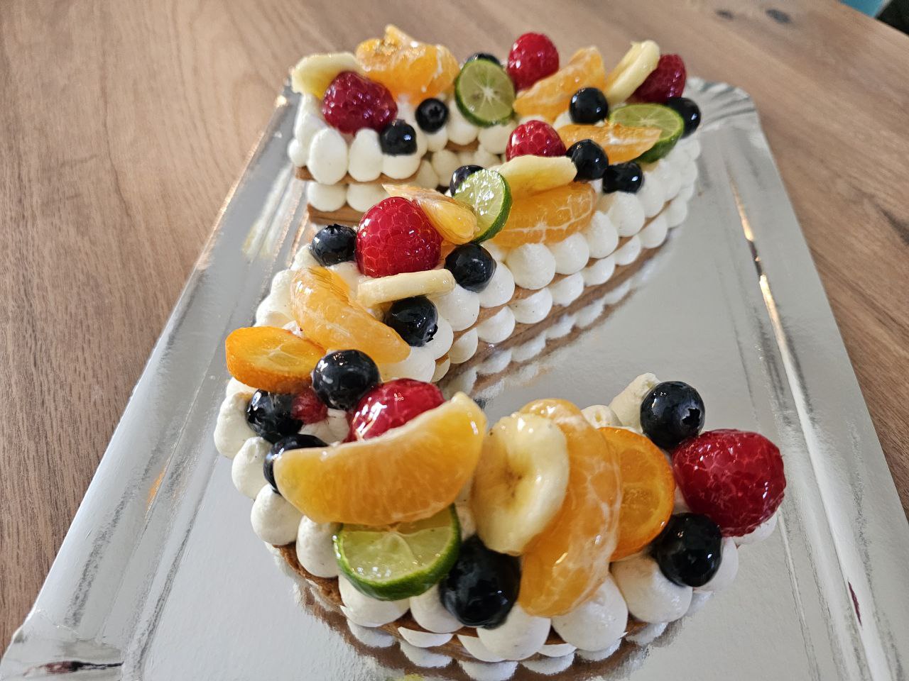 Gâteau en forme de chiffre, composée d'une pâte sablée, d'une crème vanille mascarpone et de fruits frais au choix.