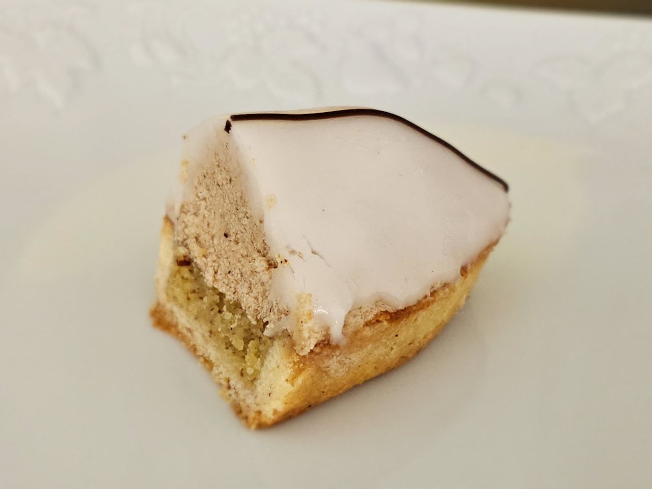 Barquette aux marrons composée d'une pâte sablée aux amandes, d'une mousse au marron et d'un glaçage à la vanille surmonté un trait de chocolat.